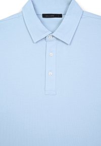 Polo shirt azzurro chiaro realizzato in tessuto morbido, con colletto, patta con tre bottoni e un'etichetta che recita "CALLIOPE" in taglia L.