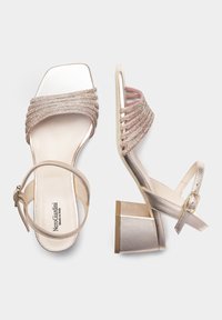 Sandali con tacco a blocco, con cinturini, in oro metallico e rosa chiaro, caratterizzati da un design incrociato testurizzato e una cinghia regolabile alla caviglia.