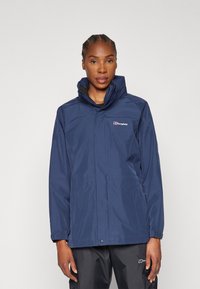 Navy waterproof jacket with a high collar and adjustable hood, featuring a logo on the left chest and side pockets. Smooth texture.