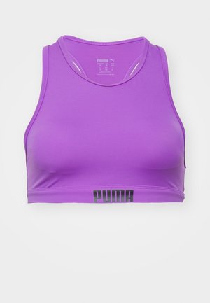 Purpurna športna crop majica z okroglo izrezom, izdelana iz gladkega materiala. Ima črni logotip "PUMA" ob spodnjem robu.