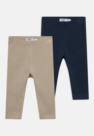 Dos pares de leggings para niños pequeños: uno beige y otro azul marino, ambos con un tejido de punto tipo gofre texturizado y cinturillas elásticas.