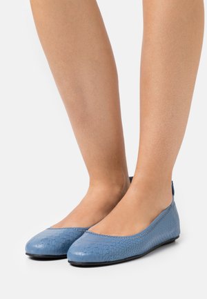 Ballerines bleu clair en matériau texturé, avec une découpe basse, un bout arrondi et des coutures visibles le long du bord.