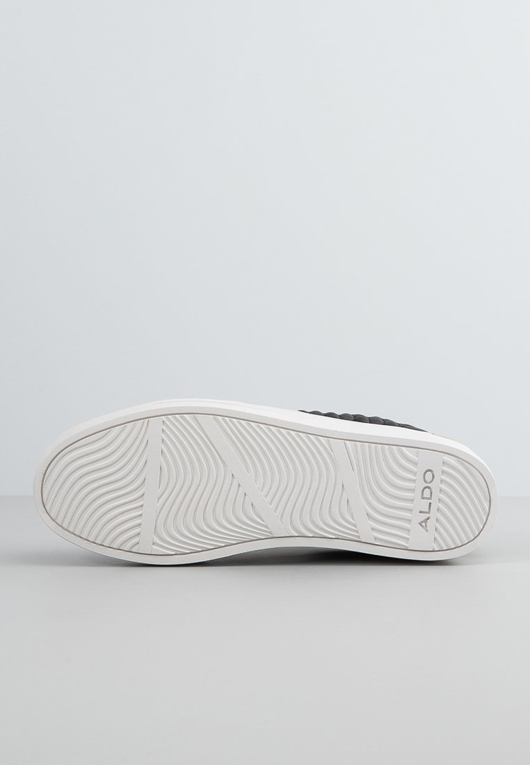 Basket noire avec une tige texturée, semelle en caoutchouc blanc avec un motif ondulé et le logo de la marque. Design élégant, convenant pour une tenue décontractée.