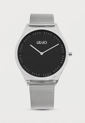 Orologio da polso analogico argento con quadrante nero, indici orari minimalisti e cinturino in metallo a maglia, mostra l'ora 10:10:08, marchio "LIU•JO" sul quadrante.