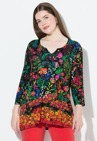 Schwarze Tunika mit lebhaftem floralem Druck in Rot, Pink, Blau und Grün. V-Ausschnitt, drei Viertel Ärmel und fließender Saum.