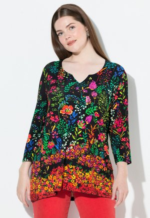 Zwarte tuniek met een levendig bloemenprint in rood, roze, blauw en groen. V-hals, driekwart mouwen en een vloeiende onderkant.