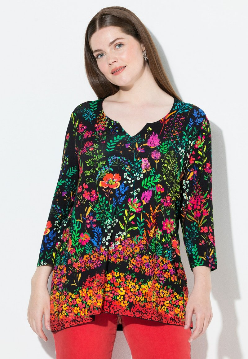 Schwarze Tunika mit lebhaftem floralem Druck in Rot, Pink, Blau und Grün. V-Ausschnitt, drei Viertel Ärmel und fließender Saum.