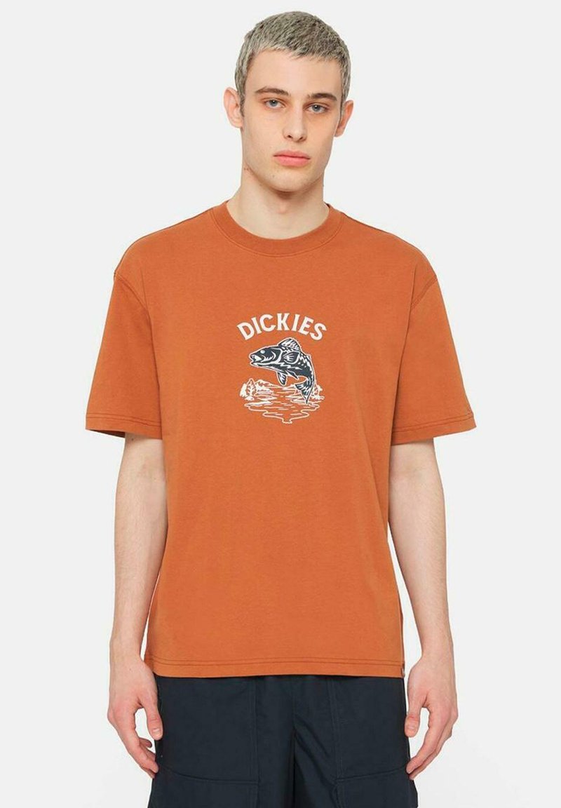 Camiseta de algodón naranja con mangas cortas y cuello redondo. Presenta un gráfico de un pez y la palabra "DICKIES" en blanco encima del diseño.