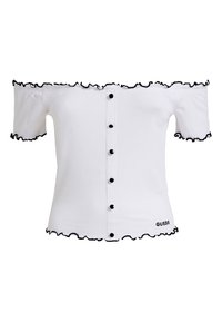Haut blanc à épaules dénudées avec bordure à volants noirs, fermeture à boutons sur le devant, texture côtelée, et logo "GUESS" près de l'ourlet.