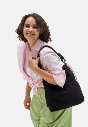 Borsa tote in tessuto nero con una texture morbida, caratterizzata da un accento rosa e un dettaglio firmato. La borsa ha manici robusti e regolabili per il trasporto.