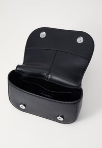 Borsa a tracolla in pelle nera con flap arrotondato, chiusura a scatto in argento e una superficie liscia. All'interno presenta un logo e tasche minime.