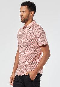 Korte mouwen overhemd met knopen, voorzien van een rood-witte geometrische print, gemaakt van lichtgewicht stof met een kraag.