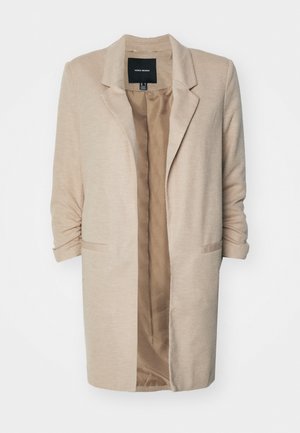 Sacou bej dintr-un material texturat, cu închidere printr-un singur nasture și deschidere frontală. Dispune de două buzunare laterale și mâneci pliate. Căptușeala interioară este într-o nuanță mai deschisă.