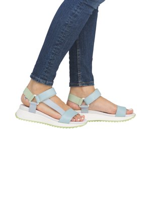 Sandales à lanières bleu clair et vert avec boucles réglables, semelle blanche épaisse et motif de grip texturé au dessous.