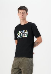 Black cotton t-shirt featuring a colorful graphic print with "JACK & JONES" text. Short sleeves and a classic crew neckline.