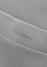 Szürke leggings, textúrált anyagból, széles gumis derékrésszel, amelyen a "LAMANIA" felirat van hímezve. Sima felület, enyhe fénnyel.