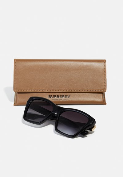 Occhiali da sole neri con lenti gradientate e montatura spessa, abbinati a un astuccio in pelle beige con logo del brand in rilievo.