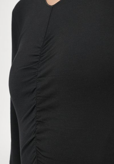 Μαύρο μπλουζάκι με μακρύ μανίκι από απαλό ύφασμα, με ραβδώσεις στο πλάι και στρογγυλή λαιμόκοψη. Ομαλή υφή.