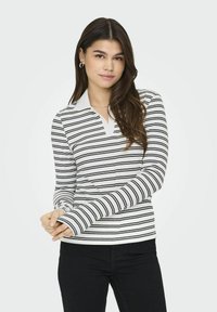 Langærmet polo-shirt i hvid med sorte vandrette striber, med en krave-halsudskæring og tætsiddende manchetter, lavet af blødt, strækbart materiale.