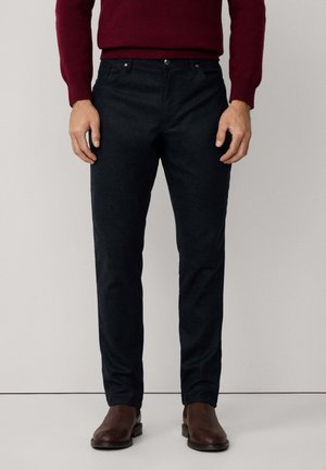 Pantalones para hombre en azul oscuro fabricados con una tela texturizada, con un diseño ajustado, bolsillos delanteros y un cierre de botón único.