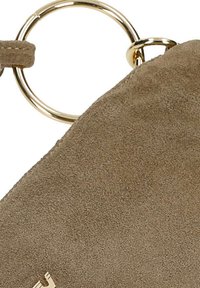 Coin de sac à main en daim taupe avec détail de poignée double anneau métallique doré.