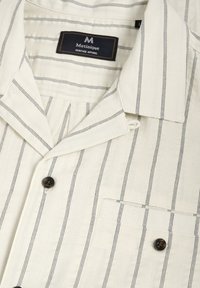 Koszula z krótkim rękawem w kolorze off-white, w niebieskie pionowe paski, z kołnierzykiem z wycięciem, przednią kieszenią i ciemnym guzikiem.