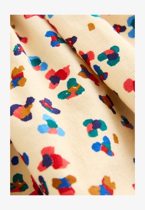 Tessuto di cotone di colore giallo con una superficie strutturata, caratterizzato da motivi astratti multicolori in rosso, blu, verde e marrone.