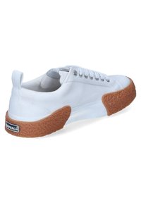 Sneaker bianca in canvas con suola in gomma marrone testurizzata e occhielli in argento. Presenta una linguetta posteriore per facilitare l'indossamento e un logo del marchio.