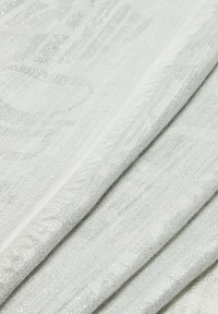 Tessuto bianco intrecciato con filato d'argento leggermente lucido, caratterizzato da un motivo testurizzato e bordi frangiati per un tocco di dettaglio.