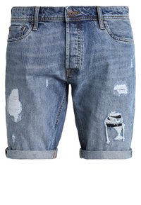 Pantalones cortos de denim azul claro con puños enrollados, que presentan múltiples parches desgastados y detalles deshilachados, mostrando un diseño casual y relajado.