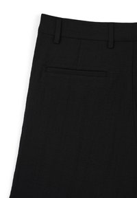 Pantaloni in lino neri con frontale piatto, passanti per cintura e una sola tasca posteriore, caratterizzati da una finitura liscia e testurizzata.