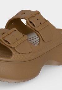 Πλατφόρμα σάνδαλος Croslite σε καφέ χρώμα με δύο ρυθμιζόμενα λουριά με αγκράφες και υφή πέλματος για άνεση και πρόσφυση.