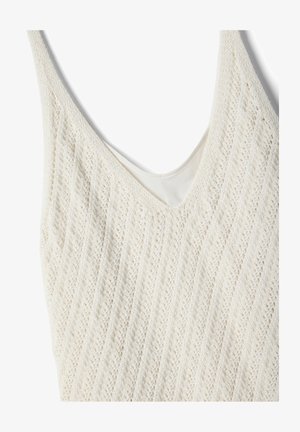 Haut sans manches en tricot crème avec un col en V et un motif subtil en ajour diagonal sur le tissu.