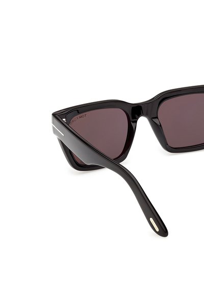 Ochelari de soare dreptunghiulari negri, cu rame groase și lucioase și lentile închise la culoare, prezentând o brațară cu un mic detaliu metalic.