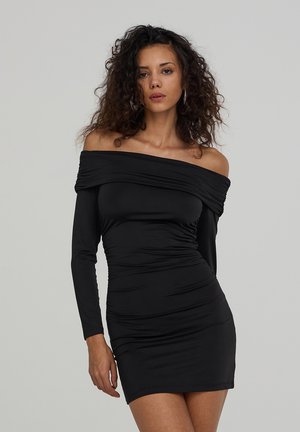 Mini dress nero a spalla scoperta con maniche lunghe, realizzato in tessuto elasticizzato. Presenta dettagli arricciati lungo il torso per un effetto aderente.