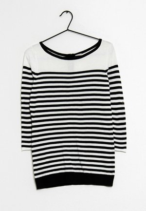 Maglione a righe bianche e nere con maniche a tre quarti, scollatura a barca ampia e orlo nero, appeso a un gancio nero.