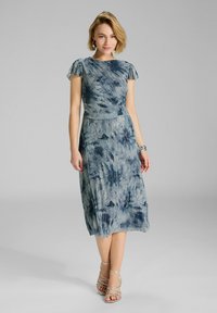 Robe imprimée bleue avec des manches courtes et flottantes, un corsage ajusté et une jupe fluide arrivant au genou ; présente une texture douce et un subtil éclat.