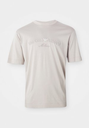 Light beige short-sleeve t-shirt made of soft fabric, featuring embroidered "Emporio Armani Milano" logo in a slightly darker shade.