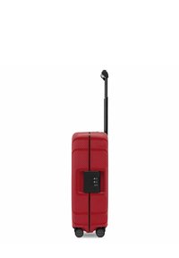 Roter Hartschalenkoffer mit einem ausziehbaren schwarzen Teleskopgriff, vier schwarzen Rädern und einem integrierten Zahlenschloss an der Seite.