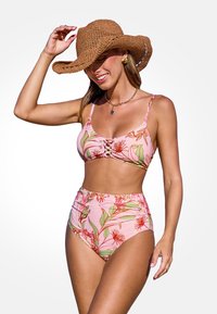 Dwuczęściowy strój kąpielowy z wysokim stanem w różowy kwiatowy wzór, z przekręconym przodem, cienkimi ramiączkami oraz dopasowaną szeroką słomkową kapeluszem.