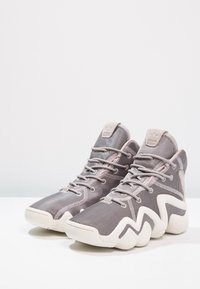 Wysokie sneakersy w szarym meshu z kremowymi akcentami. Posiadają zygzakowatą podeszwę, wyściełany kołnierz i sznurowadła. Teksturowane detale materiałowe w całej konstrukcji.