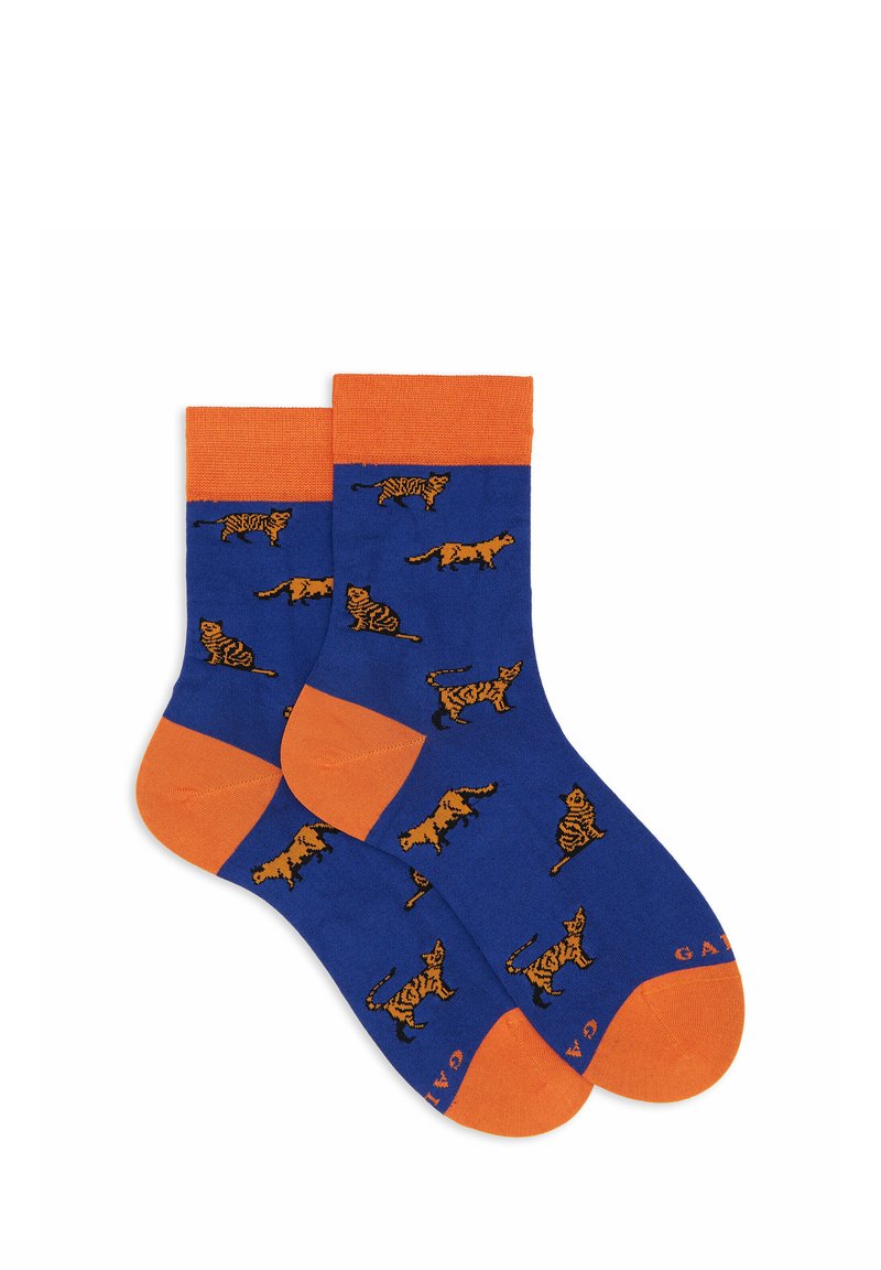Calzini di cotone blu con accenti arancioni, caratterizzati da un motivo giocoso di tigri su tutta la superficie. Tessuto morbido con bordo superiore a coste e tallone rinforzato.