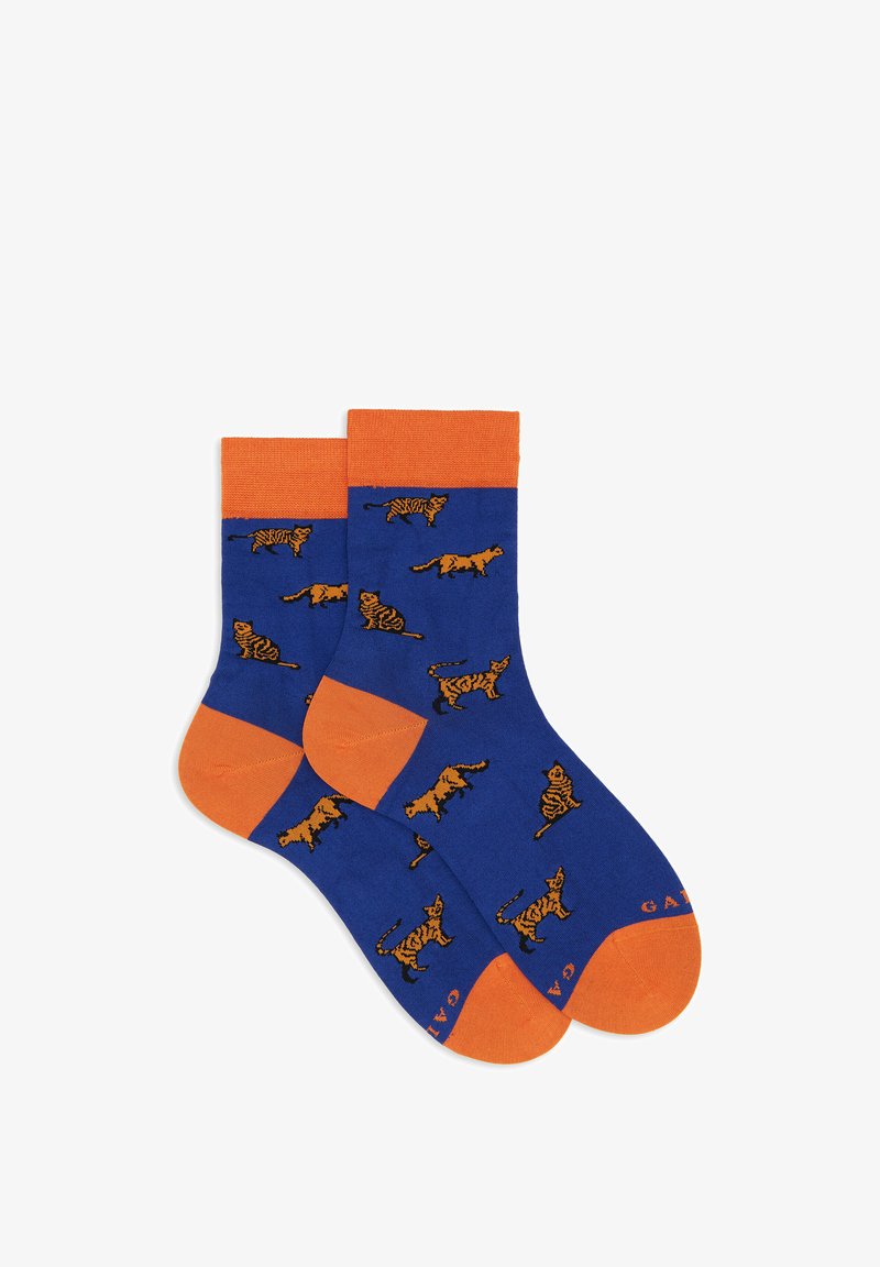 Calzini di cotone blu con accenti arancioni, caratterizzati da un motivo giocoso di tigri su tutta la superficie. Tessuto morbido con bordo superiore a coste e tallone rinforzato.