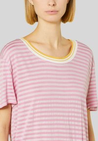 Camiseta de rayas rosas con mangas cortas, un amplio escote redondo con acentos amarillos y blancos. Tela suave con un ajuste relajado.