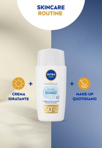 Fluido solare per il viso NIVEA Sun, bottiglia di plastica bianca, etichetta blu e oro, con SPF 50+, progettato per tutti i toni di pelle e per uso quotidiano.