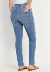 Slim jeans i ljusblå denim, med hög midja, fem fickor och en slät yta. Detaljer omfattar subtila sömmar och en klassisk passform.