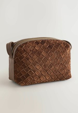Brun suede makeup taske med vævet tekstur, afrundet top og gylden lynlås. Har læderdetaljer for holdbarhed og en kompakt form.