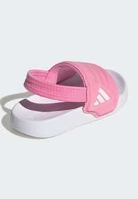 Růžové nazouváky s polstrovaným páskem, bílou podrážkou a texturovanou stélkou. Na pásku jsou tři bílé pruhy. Lehký design.