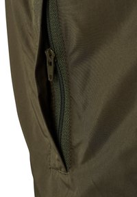 Nærbilde av et olivengrønt stoff med en delvis åpen glidelås som avslører en lommelyd inne under.