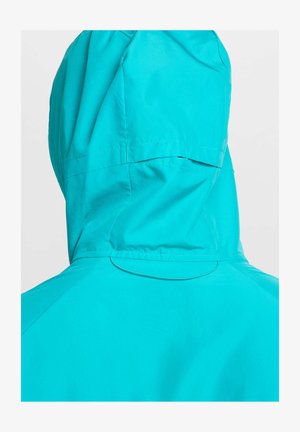 Une veste à capuche turquoise en tissu léger. Ses caractéristiques incluent un design sans couture et un dos minimaliste sans matériel visible.